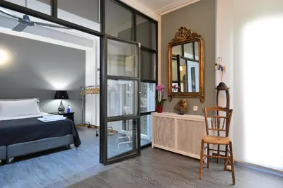 a bedroom with a bed and a mirror and a chair at Plaka Elegant Apartment in Athens