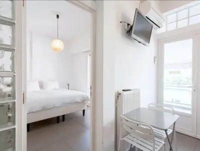 a bedroom with a bed and a tv on the wall at Acropolis Charming Apartment with Large Balcony - DM17 in Athens