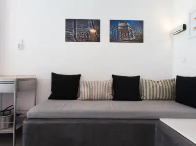 a couch in a room with three pictures on the wall at Acropolis Charming Apartment with Large Balcony - DM17 in Athens