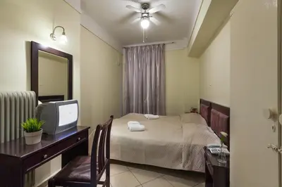 a bedroom with a bed and a desk with a television at Artemision in Athens