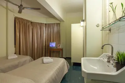 a bathroom with two beds and a sink and a tv at Artemision in Athens