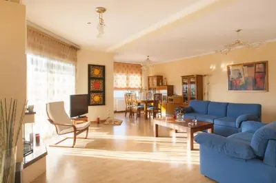 a living room with a blue couch and a table at House,1000m from beach in Lagonissi