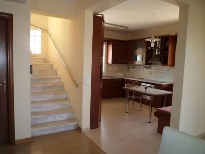a staircase in a living room with a kitchen at House,1000m from beach in Lagonissi