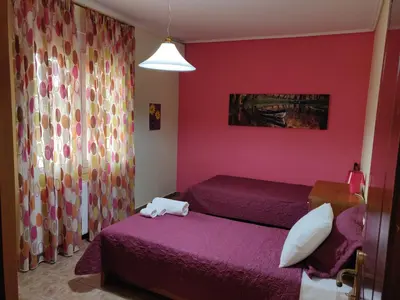 a room with two beds and a pink wall at House,1000m from beach in Lagonissi
