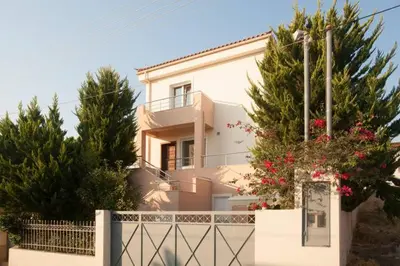 a white house with a fence and trees at House,1000m from beach in Lagonissi