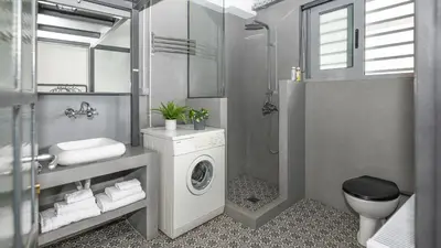 a bathroom with a washing machine and a sink at Monastiraki Factory CityCenter- Unspoiled Athens Apartments in Athens