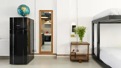 a bedroom with a black refrigerator and a mirror at Monastiraki Factory CityCenter- Unspoiled Athens Apartments in Athens