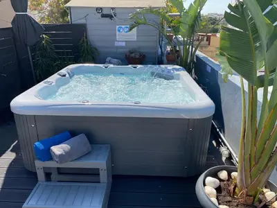 a jacuzzi tub on a patio with a plant at Monastiraki CityCenter Sleepbox- Unspoiled Athens Apartments in Athens