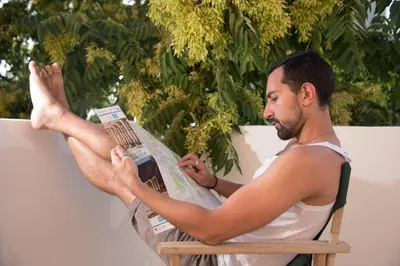 a man sitting in a chair with his feet up on a surfboard at Monastiraki CityCenter Sleepbox- Unspoiled Athens Apartments in Athens