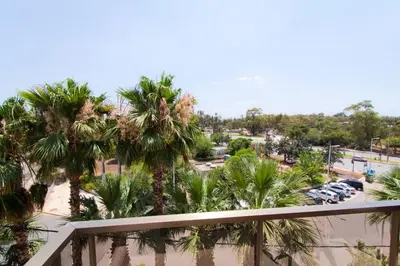 a balcony view of a parking lot with palm trees at Golden Sun Hotel in Athens