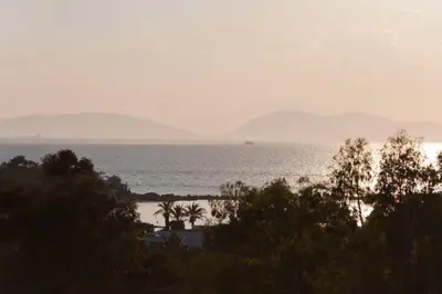 a view of the ocean with mountains in the distance at Golden Sun Hotel in Athens