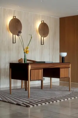 a desk with a vase of flowers on it in a room at Golden Sun Hotel in Athens
