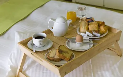 a tray with breakfast foods and coffee on a bed at Golden Sun Hotel in Athens