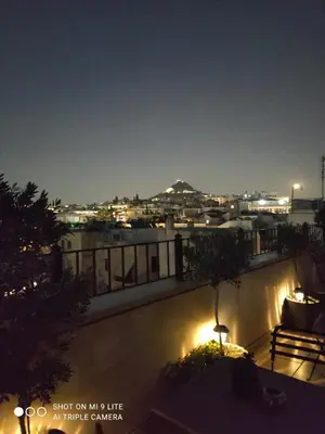 a balcony with a view of a city at night at Hotel Byron in Athens