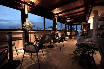 a room with tables and chairs and windows at Hotel Byron in Athens