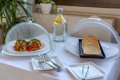 a table with two plates of food and a plate of bread at Hotel Byron in Athens