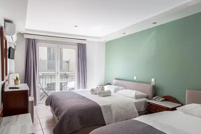 a hotel room with two beds and a window at Hotel Byron in Athens