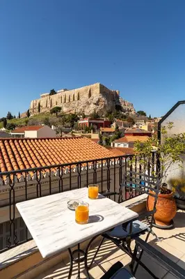 a table on a balcony with a view ofhens at Hotel Byron in Athens