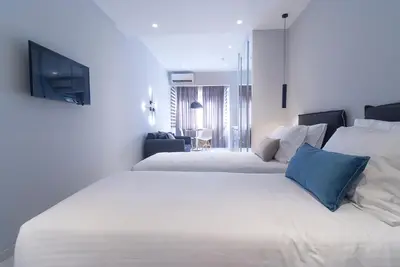 a bedroom with two beds and a tv on the wall at Acropolis Stay in Athens