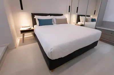a bedroom with a large white bed with blue pillows at Acropolis Stay in Athens