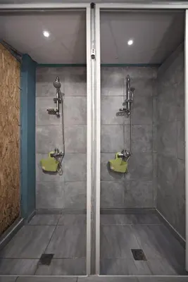 a bathroom with two urinals and two sinks at Bedbox Hostel in Athens