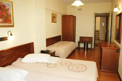 a hotel room with two beds and a desk at Omiros Hotel in Athens