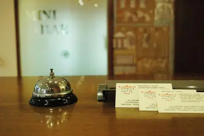 a bell and two cards sitting on a table at Omiros Hotel in Athens