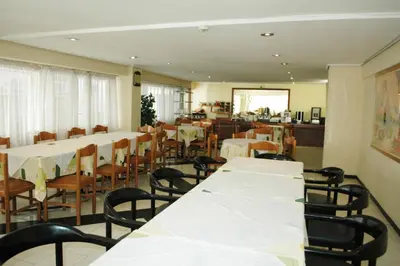 a dining room with white tables and chairs at Omiros Hotel in Athens