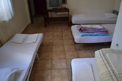 a room with three beds and a tiled floor at Argo Hotel in Athens