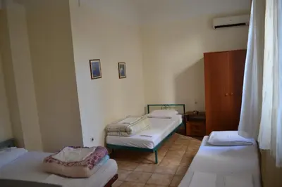 a small room with two beds and a cabinet at Argo Hotel in Athens