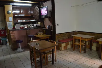 a restaurant with tables and chairs and a tv at Argo Hotel in Athens