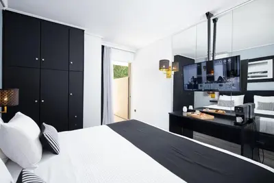 a bedroom with a black and white bed and a desk at Athenian Riviera Hotel& Suites in Athens