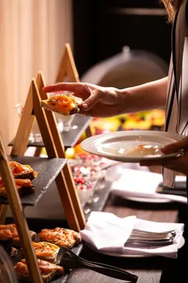 a person holding a piece of food on a table at Athenian Riviera Hotel& Suites in Athens