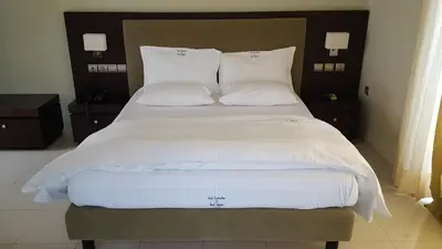 a large bed with white sheets and pillows at Sea Sight Boutique Hotel in Porto Rafti