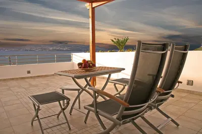a table and chairs on a balcony with an umbrella at Sea Sight Boutique Hotel in Porto Rafti