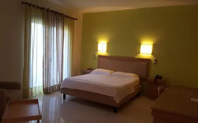 a bedroom with a bed and two lights on the wall at Sea Sight Boutique Hotel in Porto Rafti