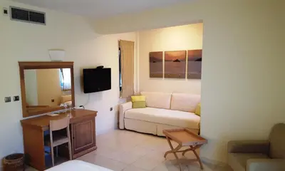 a living room with a white couch and a mirror at Sea Sight Boutique Hotel in Porto Rafti