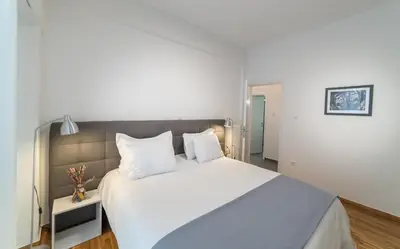 a bedroom with a large white bed with white pillows at Modern design apartment near Acropolis in Athens