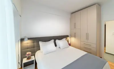 a bedroom with a large white bed and white cabinets at Modern design apartment near Acropolis in Athens