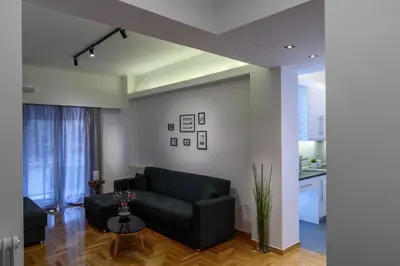 a living room with a black couch and a table at Modern design apartment near Acropolis in Athens