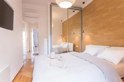 a bedroom with a large white bed with towels on it at Pagrati 2bdr Flat in Athens