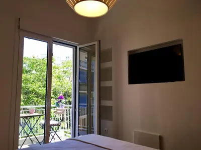 a bedroom with a flat screen tv on the wall at Pagrati 2bdr Flat in Athens