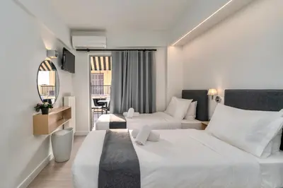 a hotel room with two beds and a couch at Hotel Adonis Athens in Athens