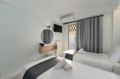 a hotel room with two beds and a mirror at Hotel Adonis Athens in Athens