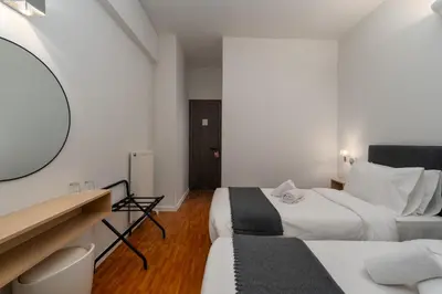 a bedroom with two beds and a mirror at Hotel Adonis Athens in Athens