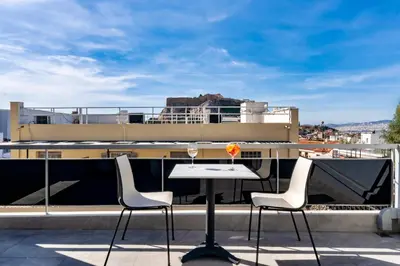 a table and chairs on the roof of a building at Hotel Adonis Athens in Athens