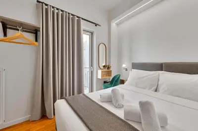 a bedroom with a white bed and a window at Hotel Adonis Athens in Athens