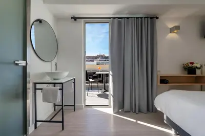 a bedroom with a bed and a sink and a mirror at Hotel Adonis Athens in Athens