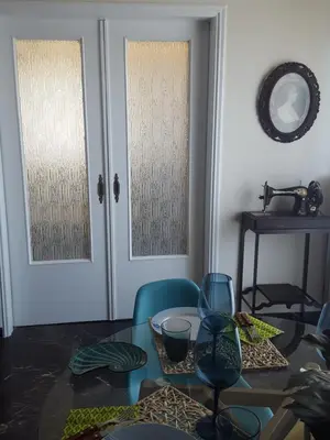a dining room with a glass table and two doors at Superb Athenian Nest in Athens