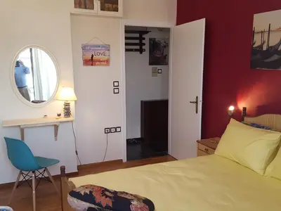 a bedroom with a bed and a chair and a window at Superb Athenian Nest in Athens